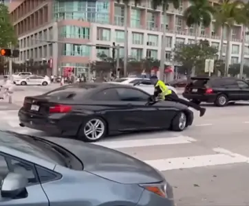 Miami police officer seen clinging to hood of car before shooting driver